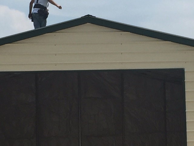 11 Photo of a crew member standing on top of a commercial garage.
