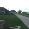 Picture of a driveway with double wide metal garage and garage doors.