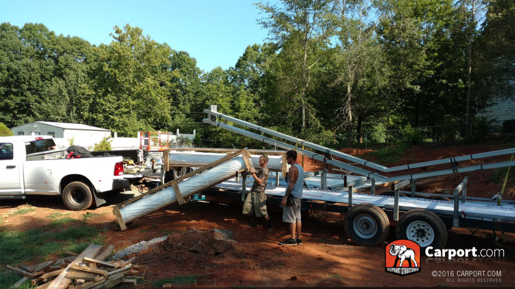 A worker carries insulation from the truck.