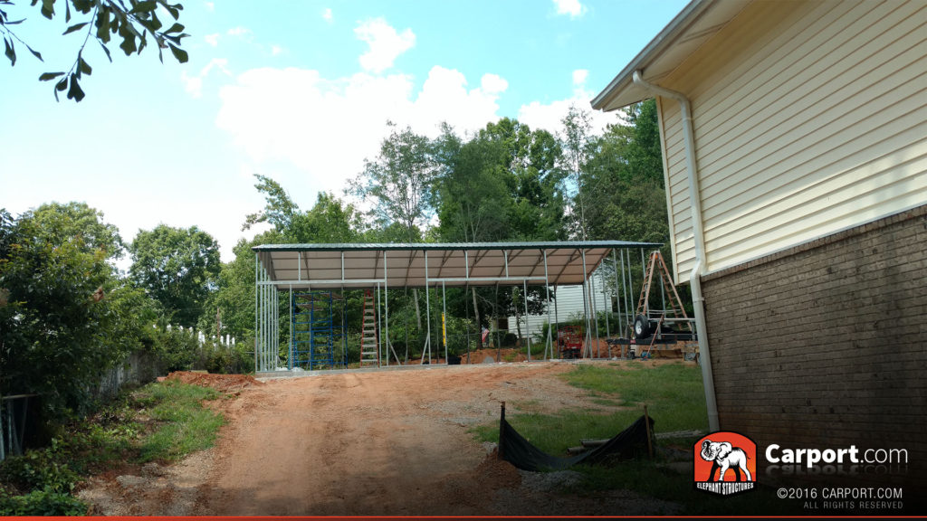 Skeleton of the garage visible from the driveway.