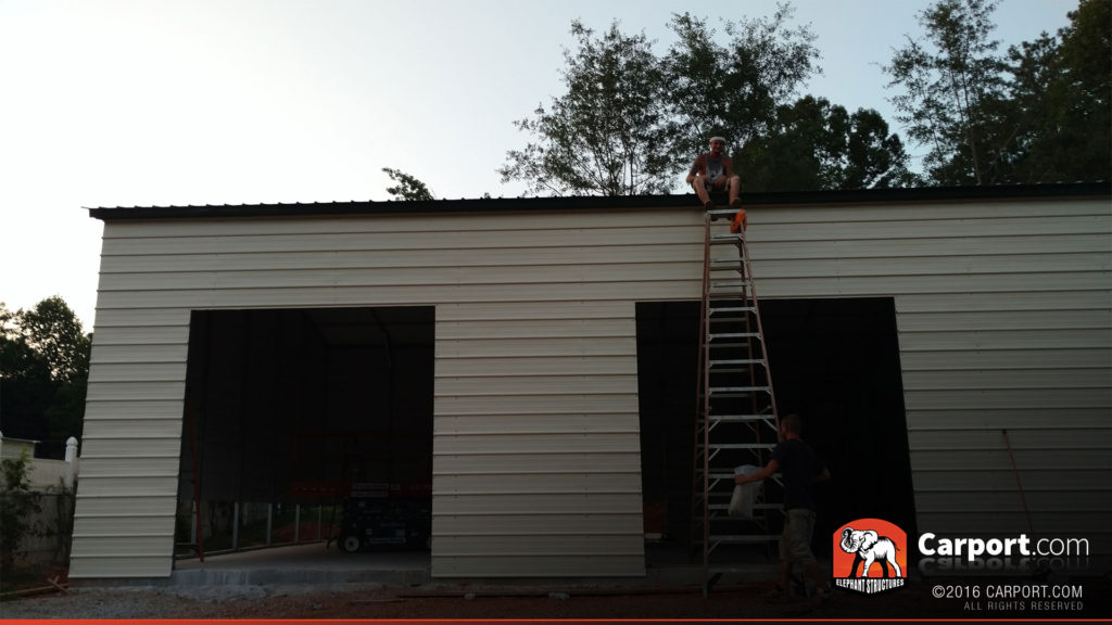 Two roll up garage door openings are visible while the crew climbs a ladder.