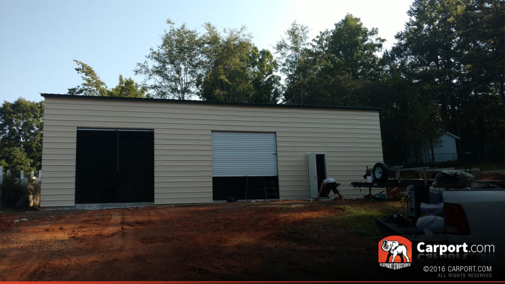 Side view of the garage where two roll-up garage doors are visible.