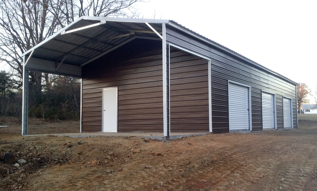 Metal building with three roll up garage doors side installed on a large utility shed, and a porch created out of the left over roofing.