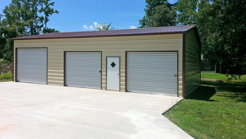 Three metal roll up garage doors with one walk in door on the front.