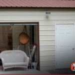 The interior is visible of this metal garage workshop.