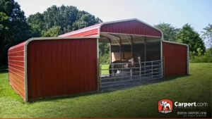 Red metal horse barn with open center shelter and enclosed side stalls
