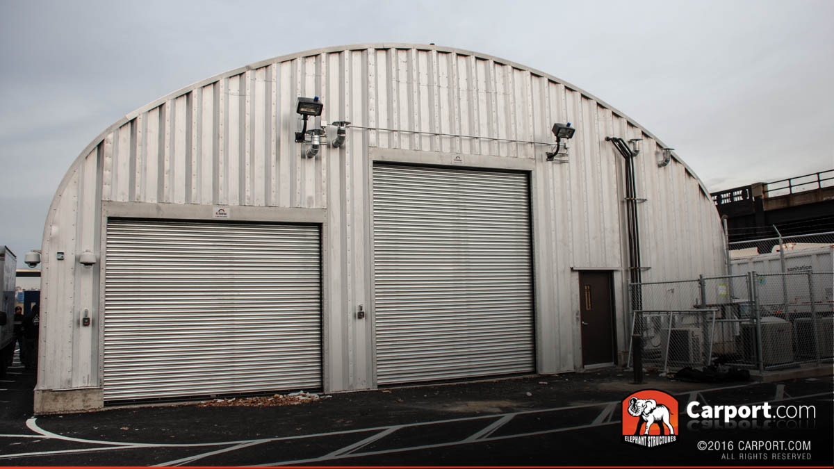 S model commercial steel arch building with two roll up garage doors in the front.